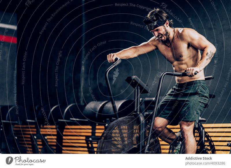 Hardworking male working out on gym bike man workout exercise bike hardworking strong training contemporary sport club fitness active muscular athletic healthy