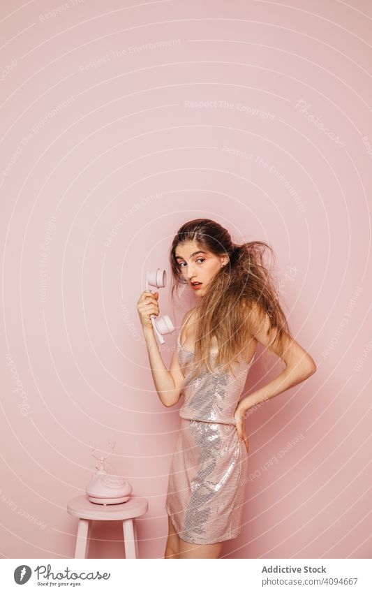 Young girl answering the phone on pink background room stylish young adult casual style indoor hipster funny copyspace connection telephone studio person device