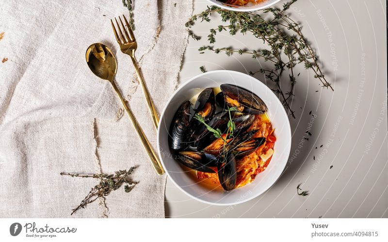 Food banner. A portion of mussels with vegetables in a white bowl on a light background. Delicious and healthy seafood. Shellfish. Top view food banner