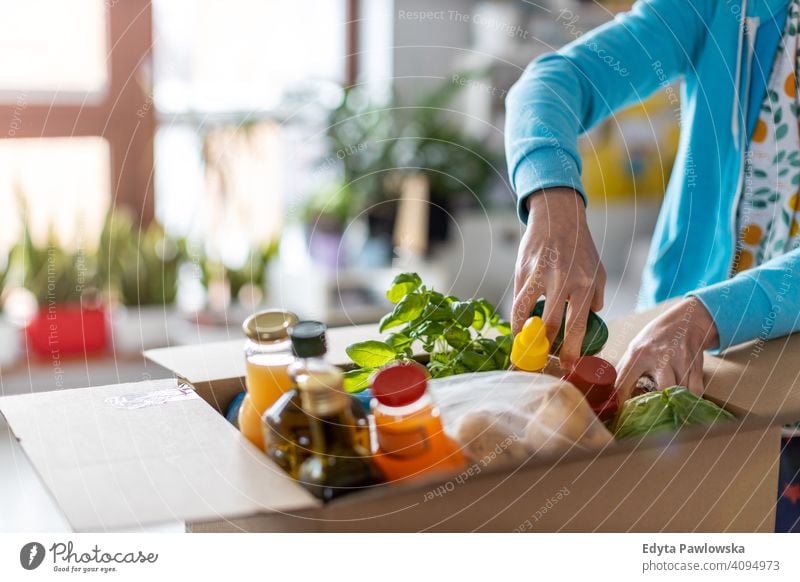 Woman unpacking box of food at home supermarket store fruit vegetables healthy groceries grocery organic fresh kitchen diet meal cooking eating house flat