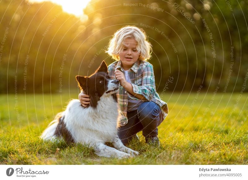 Little boy playing with his dog outdoors in the park people child little boy kids childhood casual cute beautiful portrait lifestyle elementary leisure