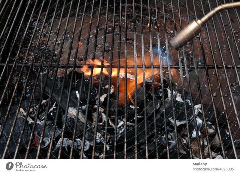 Gas flame of a welding machine for heating the embers of a charcoal barbecue at a barbecue in Rudersau near Rottenbuch in the district of Weilheim-Schongau in Upper Bavaria