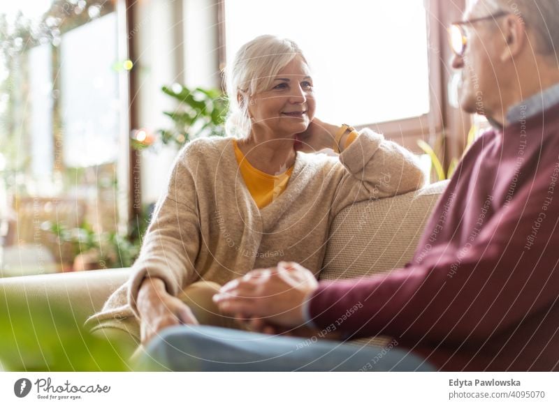 Portrait of a senior couple relaxing at home people woman adult mature casual attractive female smiling happy Caucasian toothy enjoying two people love