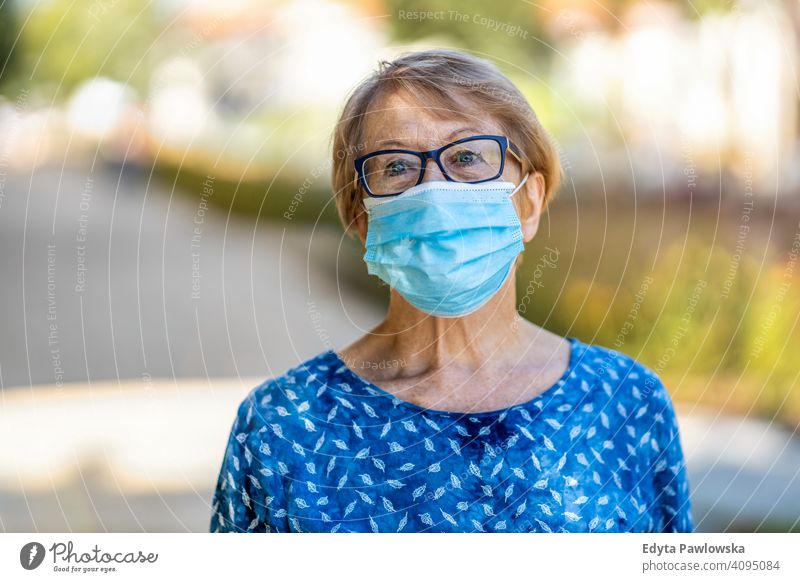 Portrait of senior woman wearing protective face mask outdoors in city people mature casual female Caucasian elderly old grandmother pensioner grandparent