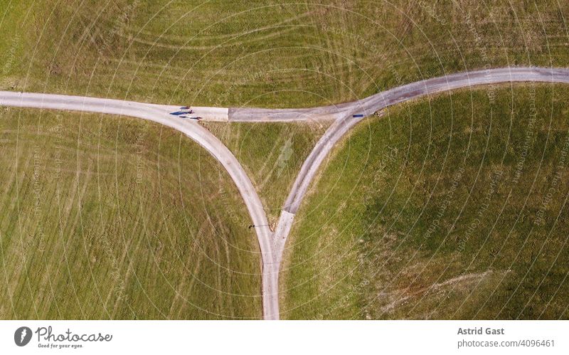 Aerial view with a drone in spring of a road crossing with a cyclist with dogs Aerial photograph drone photo Street FIELDWALKS Crossroads Triangle triangular