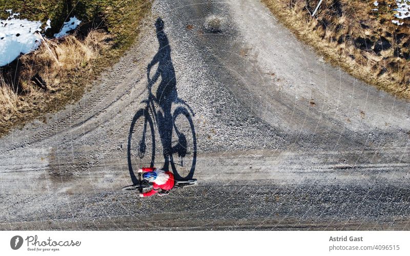 Aerial shot with a drone of a cyclist on a road with shadow Aerial photograph drone photo Spring Sports Cycling Bicycle Woman Driver Driving Street