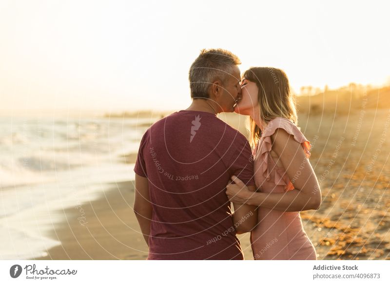 Adult couple embracing near sea beach resort love hug date smile happy vacation man woman adult honeymoon summer shore coast relationship water embrace ocean