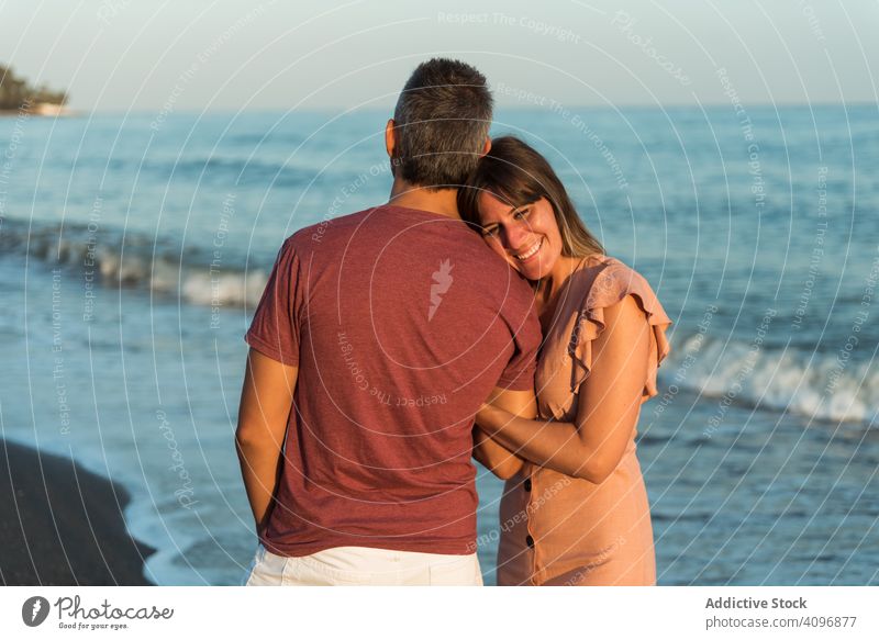 Adult couple embracing near sea beach resort love hug date smile happy vacation man woman adult honeymoon summer shore coast relationship water embrace ocean