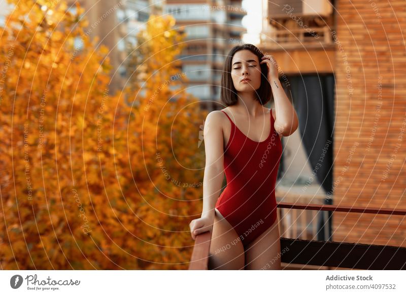 Pretty female standing on balcony in autumn woman gorgeous glamorous seductive fashionable stylish model swimsuit lingerie vogue attractive chic serious sensual
