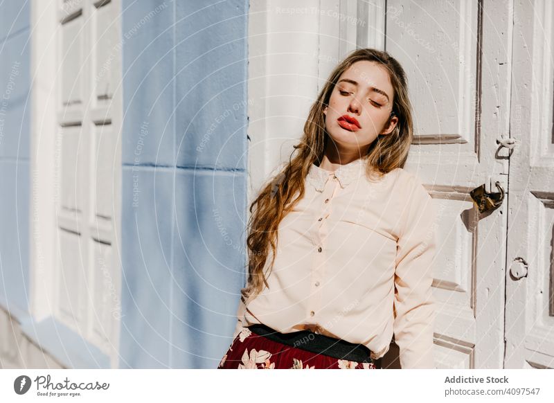 Sensual female protecting face from sun near doorway woman stylish street building sunny protection closed eyes young sensual urban fashion model cool trendy