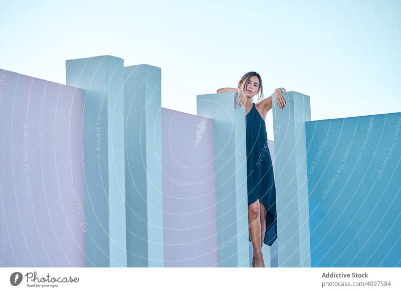 Woman standing on the top of a blue building woman casual elegant construction structure geometric architecture urban facade wall abstract exterior innovation
