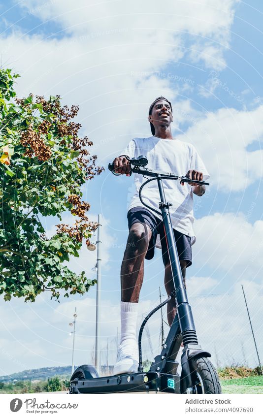 Black man riding on electric scooter in park modern black balance wheel african american movement transportation city trendy body asphalt urban entertainment