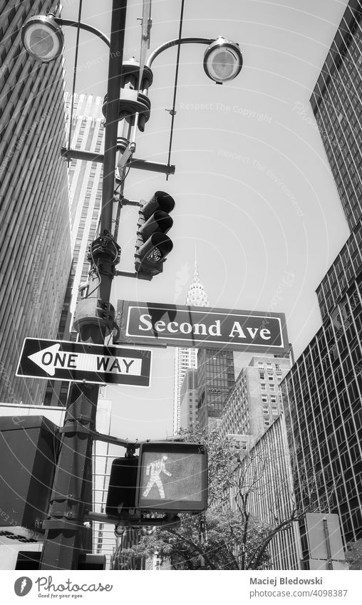 Manhattan cityscape with Second Avenue and One Way street signs on a traffic light post, New York City, USA. black and white one way skyscraper NYC B&W building
