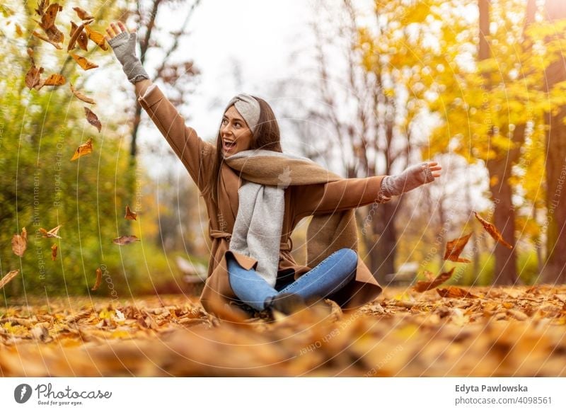 Portrait of smiling young woman in a park in autumn nature leaves freedom healthy trees yellow forest season public park relax serene tranquil fall outdoors