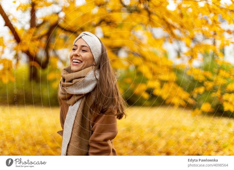 Portrait of a young woman in winter clothes and a hat wrapped in a scarf  with a big smile - a Royalty Free Stock Photo from Photocase