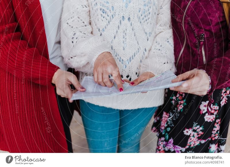 close up of group of three young caucasian women at train station reading a map. Travel and friendship concept unrecognizable travel together fun 3 board