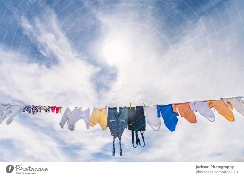 A lot of small baby clothes hanging  against blue sky dry laundry pin architecture body grow boy building care child city clean clothesline clothing cord cotton