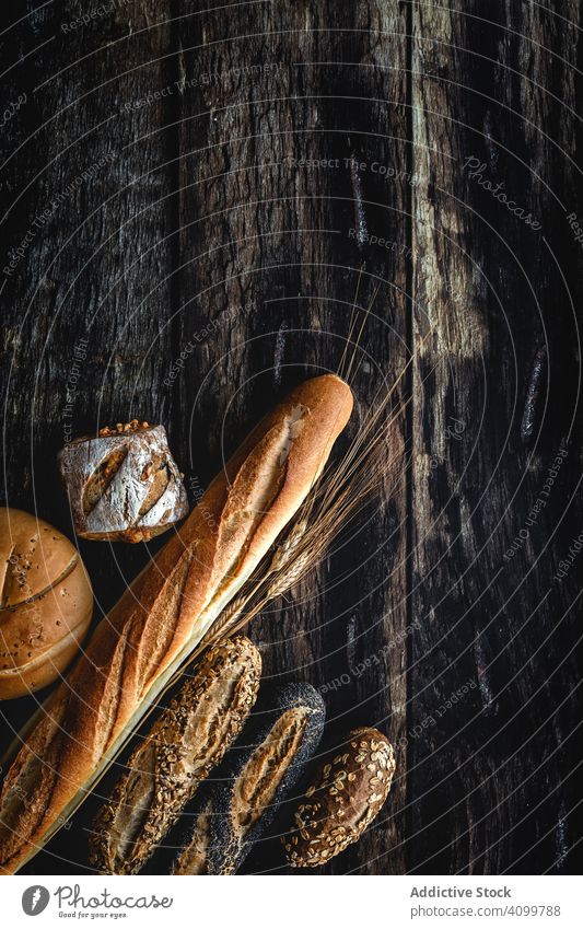 Assorted gold homemade bread on dark wood background food bakery wheat breakfast knolling organic rustic assortment tasty from above flat lay bake natural