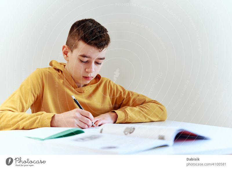 Teenage boy write homework at home. Education concept school writing studying education book person student people childhood caucasian desk young learning