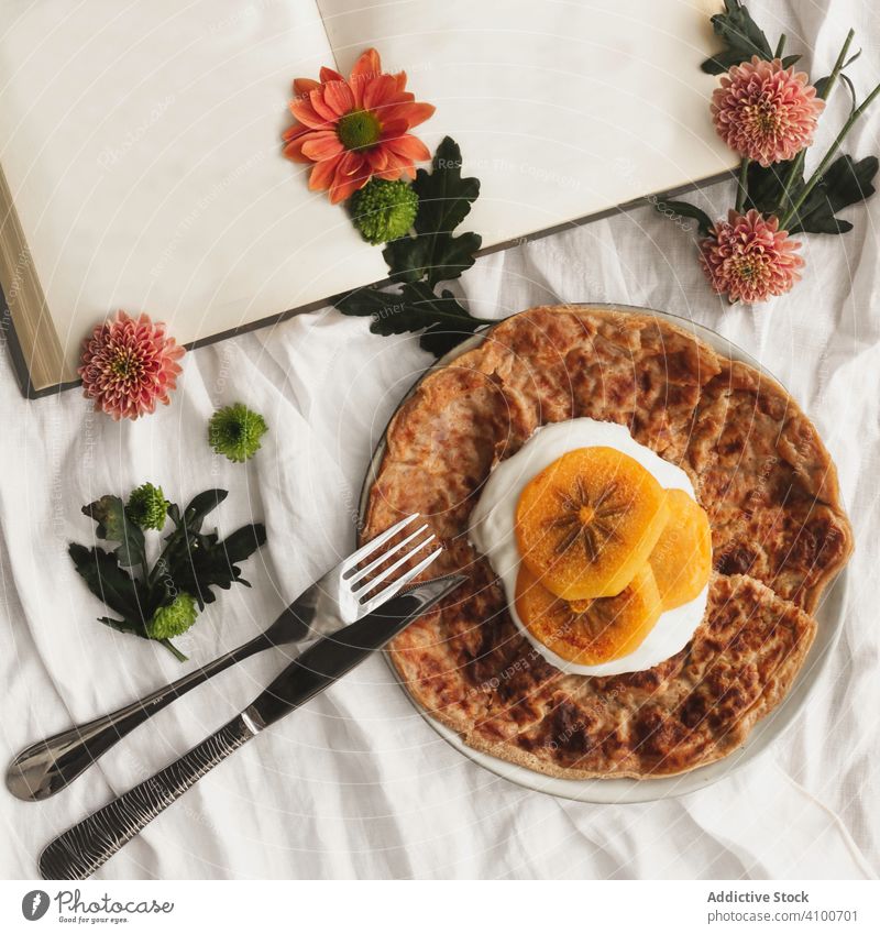 Crepes with cream and persimmon crepe fruit food ruddy dessert tasty fork portion knife book flowers slice delicious plate cloth gourmet appetizing pancake