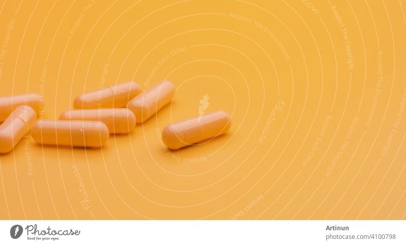 Yellow capsule pills on yellow background with copy space. Pharmacy and health insurance concept. Prescription drugs. Pharmaceutical industry. Vitamins and supplements. Marketing for pharmacy company.