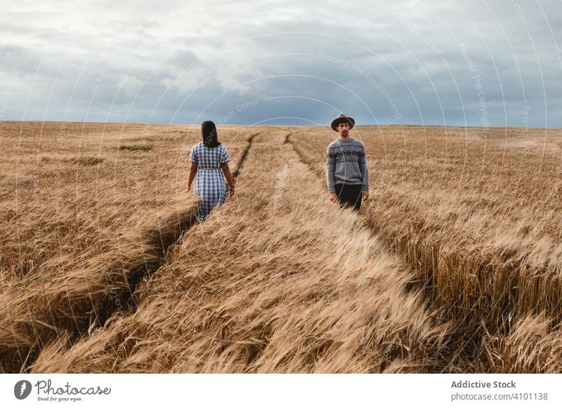 People walking on boundless field people opposite direction woman footpath pathway immense countryside nature scotland scottish cloudy sky dull grey grass gold