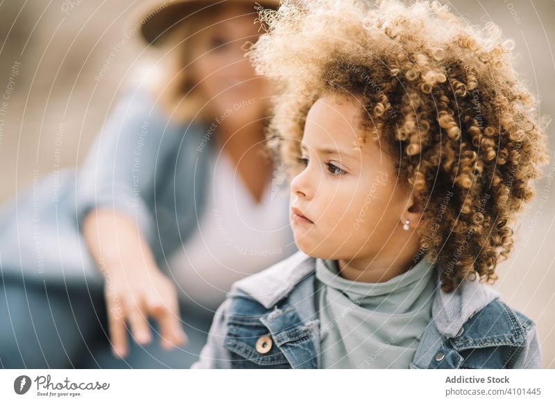 Focused curly child resting with mother nature concentration pensive adorable focused wind casual human face lifestyle headshot charming toddler cute think