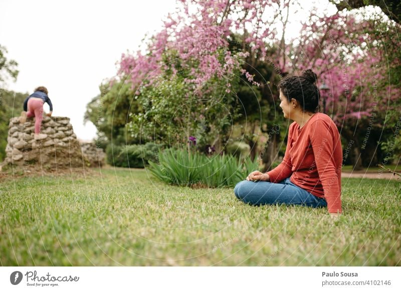 Mother watching daughter playing in the park motherhood Mother with child Daughter Family & Relations Together togetherness Lifestyle care Caucasian Woman