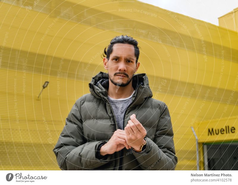 portrait of a hispanic man in a yellow background local business sunlight day one person hispanic ethnicity confident casual clothing young adult work