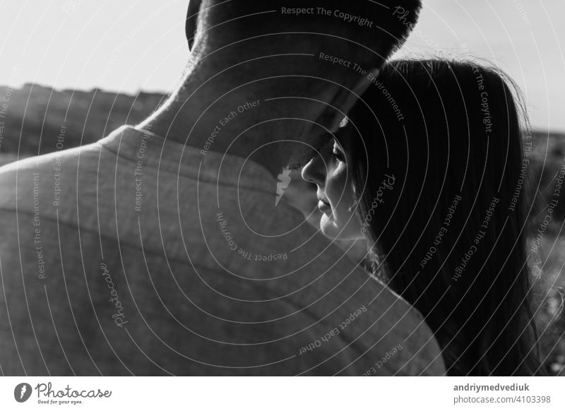 black and white photo of young loving couple hugging outside. concept of happiness and love. close up photo. love story portrait season together people fun body