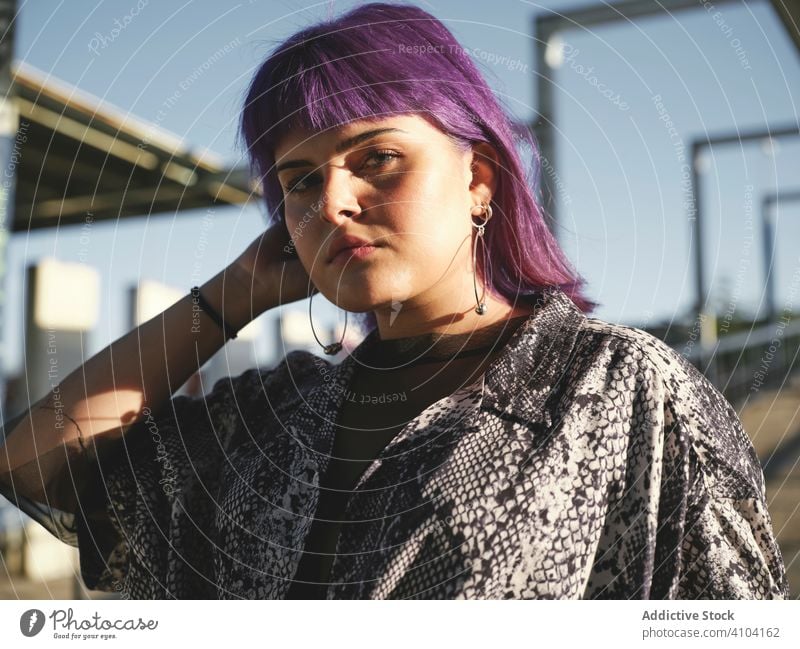 Woman with purple hair looking at camera woman stylish urban hairstyle construction shiny structure district confident fashion young model street human female