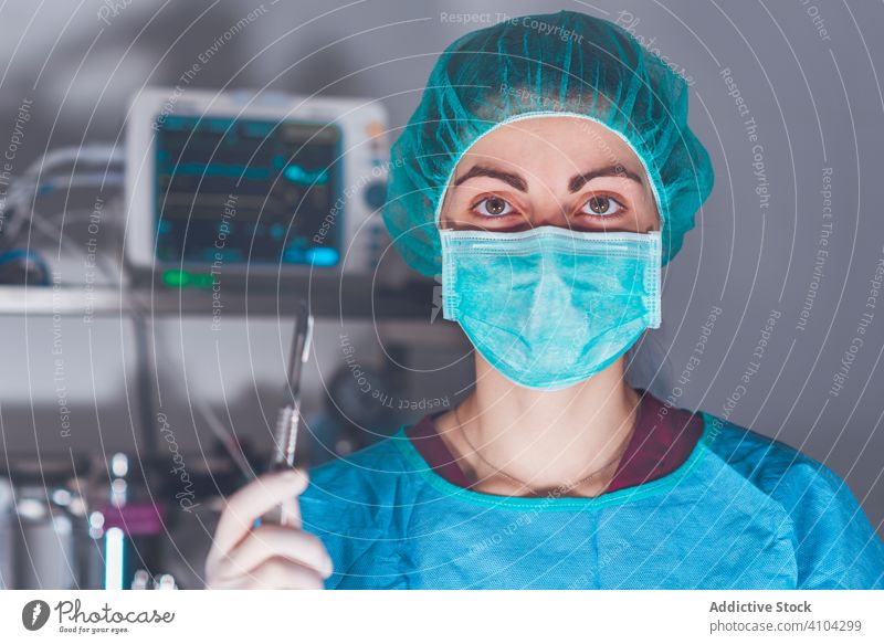 Female surgeon in operating theater hospital scalpel mask hat ready woman work doctor healthcare female sharp lancet sterile knife tool instrument job uniform