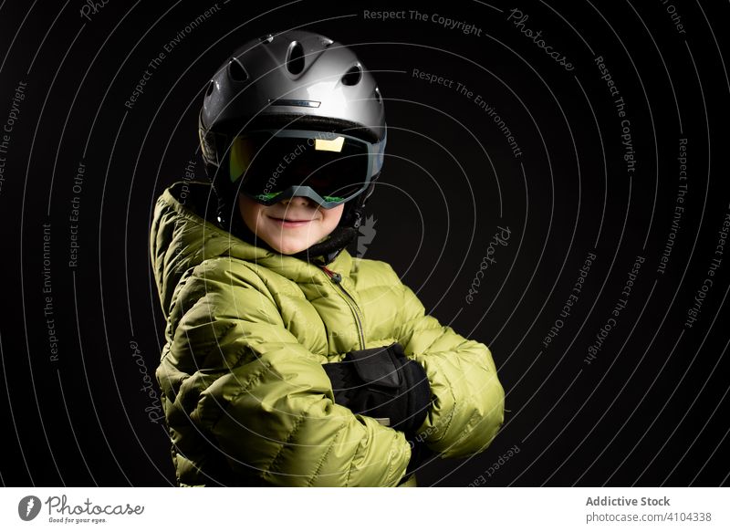 Serious little child in ski equipment in studio kid sportive winter ski goggles skier boy male healthy ready protection warm active vacation sportswear extreme