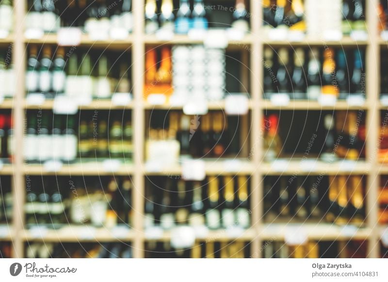 Blurred image of bottles with alcohol on the shelves in supermarket. wine beverage background abstract retail shop store winery rack row shelf blur cellar