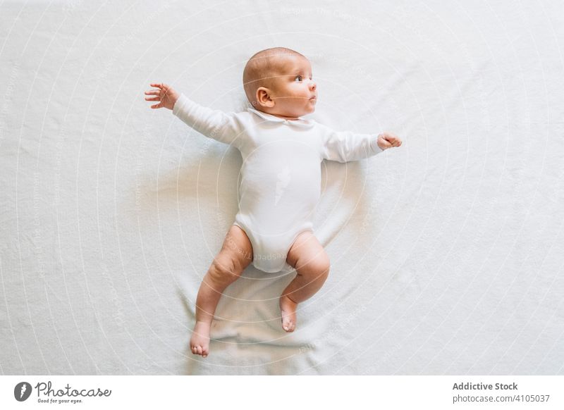 Adorable newborn baby lying on bed home infant adorable child calm small cute kid sweet pajama casual innocent peaceful open mouth rest house day comfortable