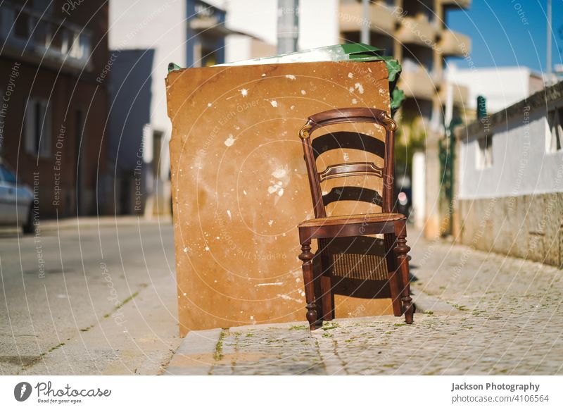 Vintage wooden chair next to trash bin on the public street rubbish outdoor dirty spotted painted faro portugal sunny art abandoned neglected dustbin trash can