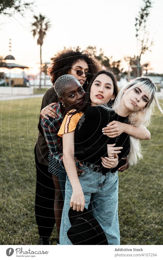 Multiethnic group of female hipsters cuddling with each one women young style smile hug portrait together friend diverse multiracial multiethnic hugging