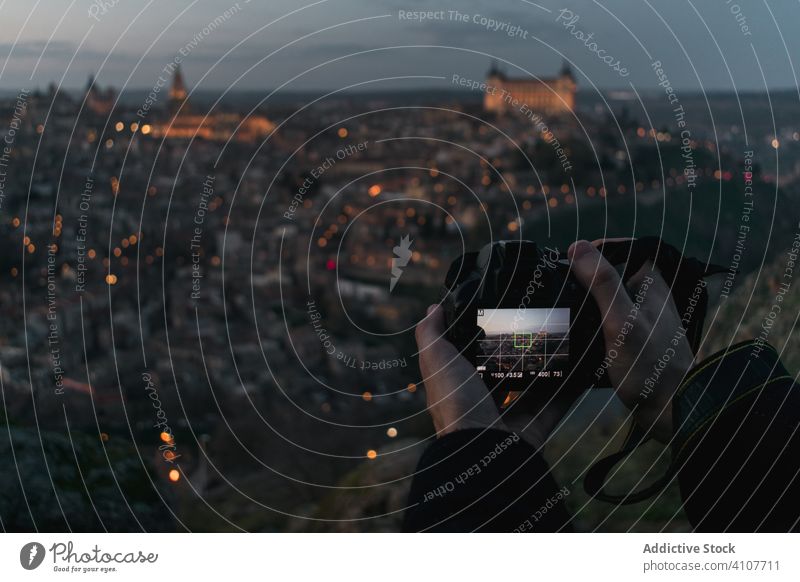 Photographer taking picture of old city in twilight take photo camera travel medieval vacation trip tourism hand photography sightseeing shoot spain toledo