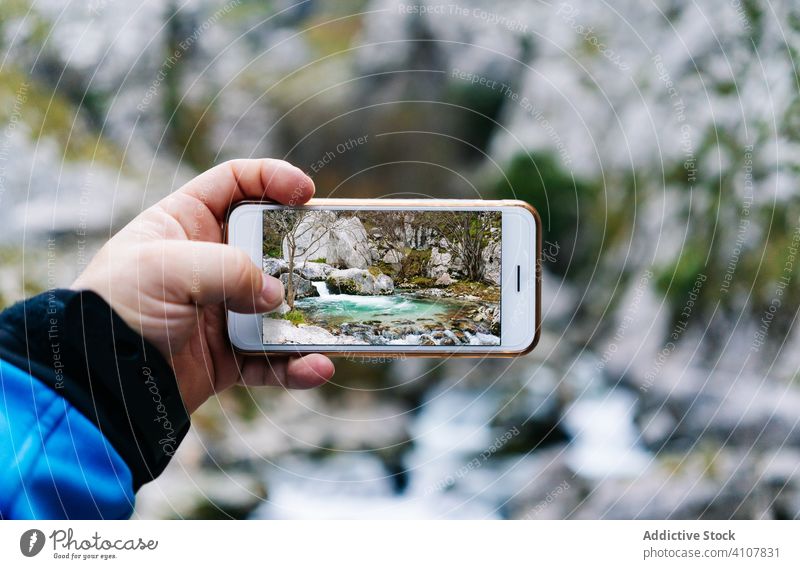 Anonymous person taking photo of mountain landscape on smartphone screen using gadget device camera picture display photographer capture image digital tourist