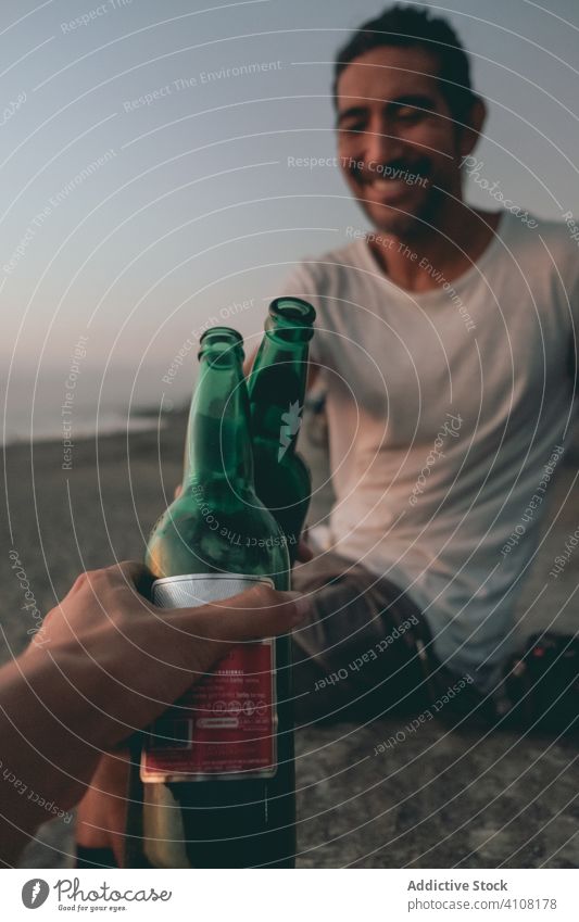 Friends toasting with beer on sunset beach bottle friend summer sea sky hand clink together relax enjoy drink alcohol beverage weekend evening vacation coast