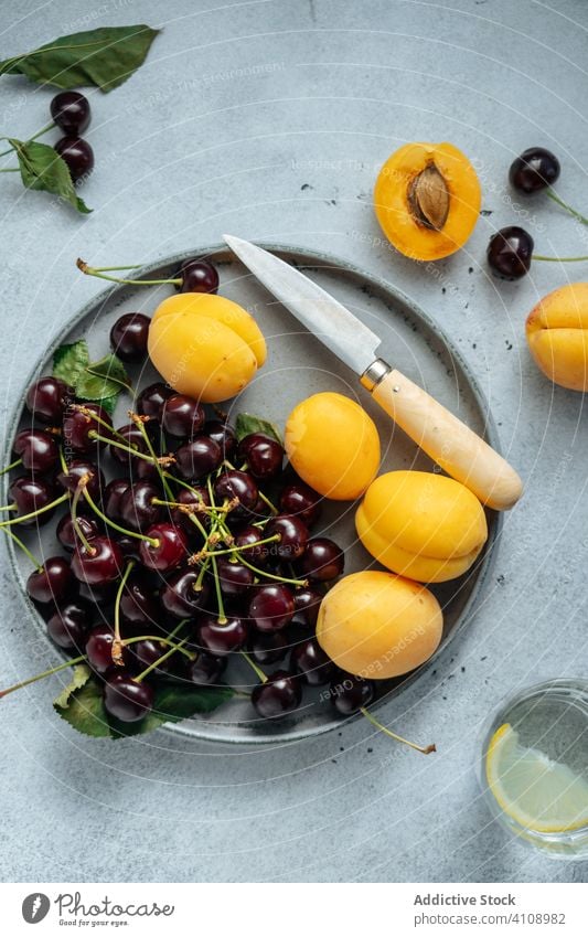 Cherry and peach on round plate fruit cherry arrangement colors studio exotic sweet composition healthy minimalist fresh dessert delicious vitamin juicy