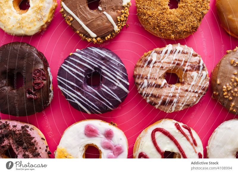 Variety of doughnuts on pink background variety assortment sweet icing glazed food donut sugar bakery pastry sprinkle fried colorful many dessert delicious