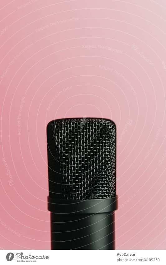 Minimalistic image of a streaming microphone over an pastel pink background with copy space, minimal concept, technology streaming mockup blue streamers
