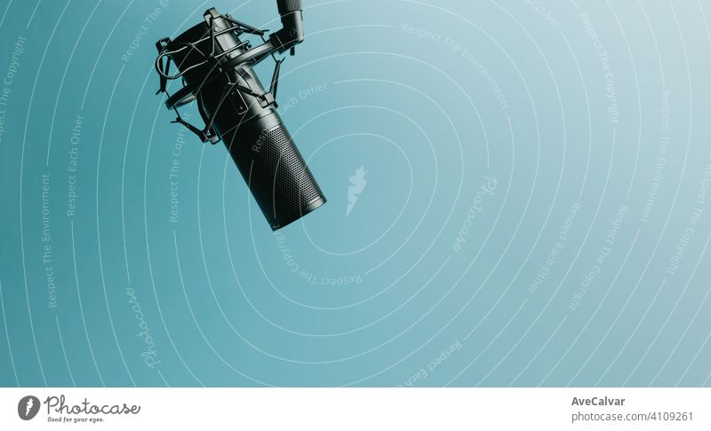 Minimalistic image of a streaming microphone over an pastel blue background with copy space, minimal concept, technology streaming mockup pink streamers