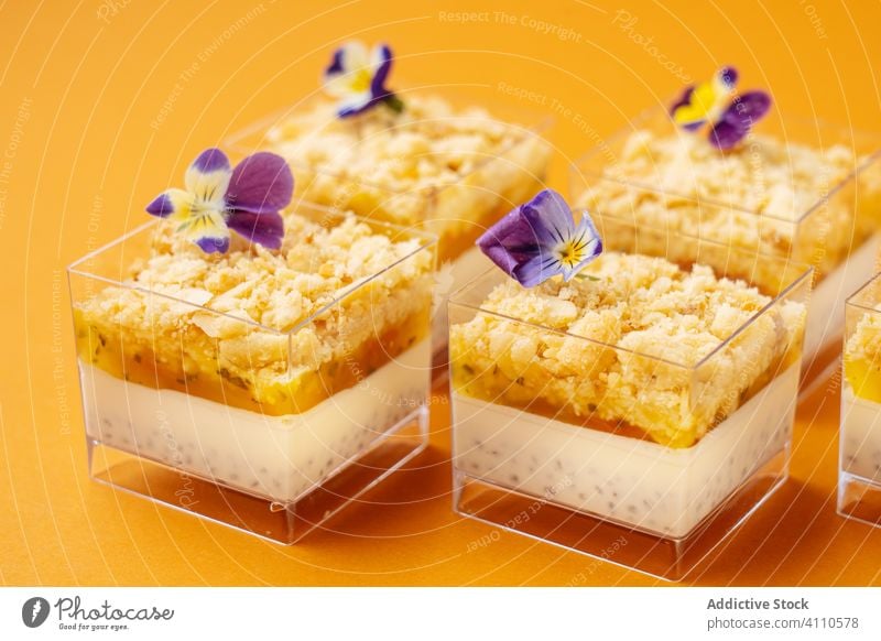 Containers with tasty dessert decorated with flowers cup sweet food pastry cuisine dish delicious yummy scrumptious sugar calorie portion baked gourmet prepared