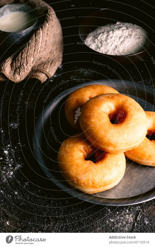 Doughnuts near ingredients on table doughnut cook kitchen recipe flour milk egg utensil pastry food napkin spoon tasty delicious bakery fresh sweet dessert