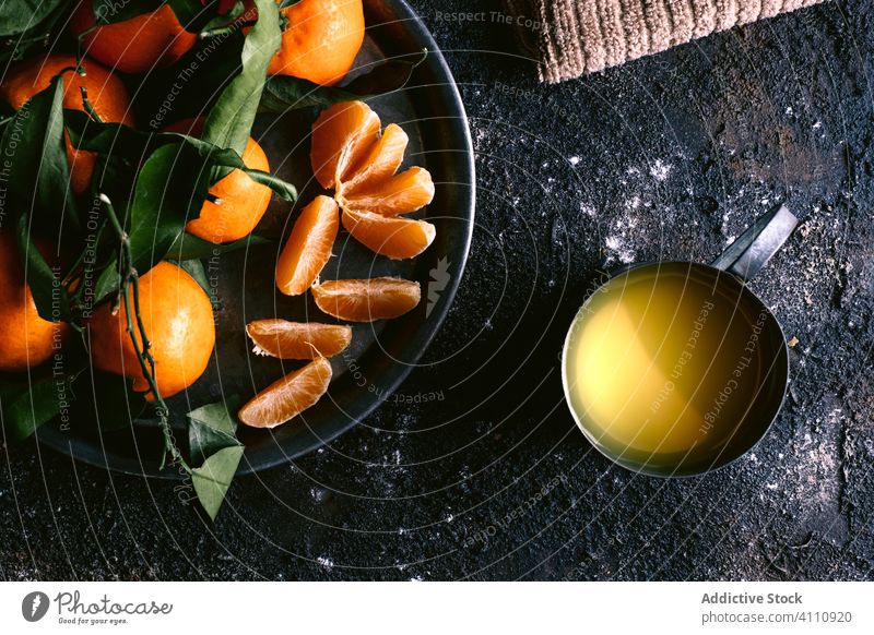 Fresh juice and tangerines on black table fresh ripe fruit rough napkin plate mug food organic citrus healthy natural delicious rustic vitamin sweet ingredient