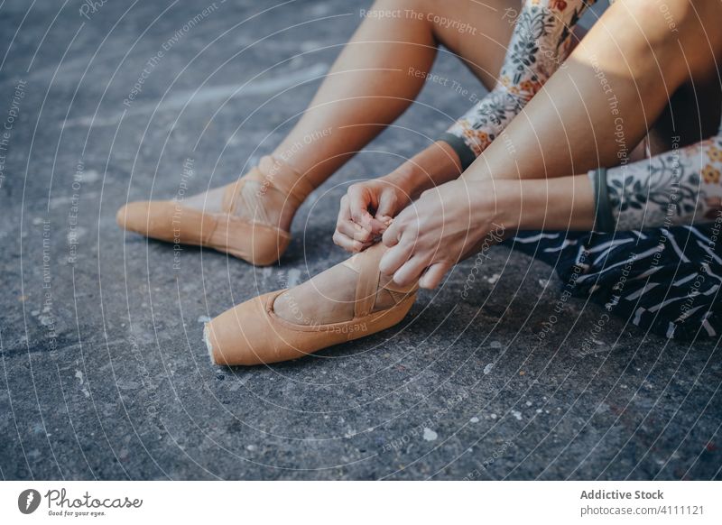 Woman sitting on floor and putting on ballet shoes ballerina pointe put on woman classic dancer choreography prepare female elegant footwear activity practice