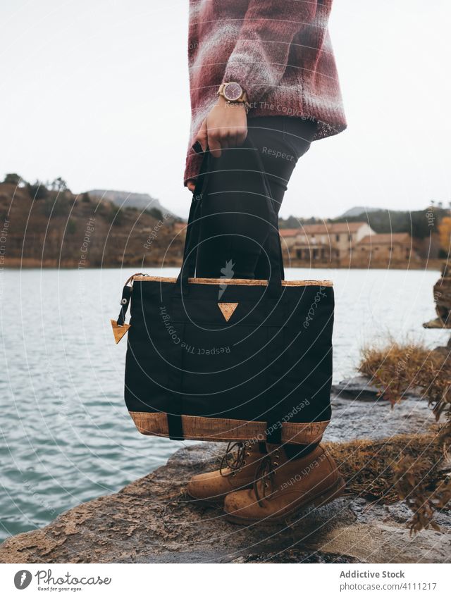 Trendy woman with bag standing near lake style trendy water active fashion modern river autumn female journey travel casual adventure lifestyle cool model
