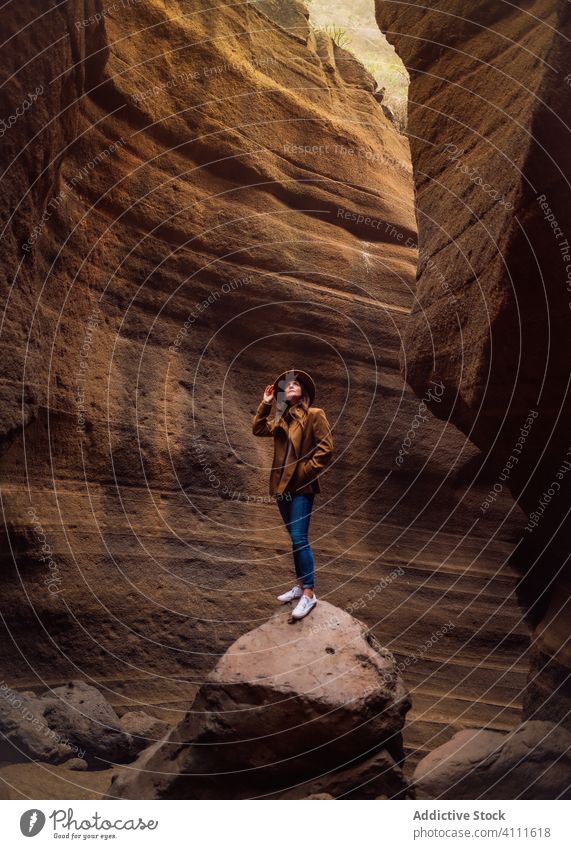 Woman standing on stone in ravine travel rock nature woman adventure explore tourism vacation mountain journey hike canyon female extreme holiday gorge activity